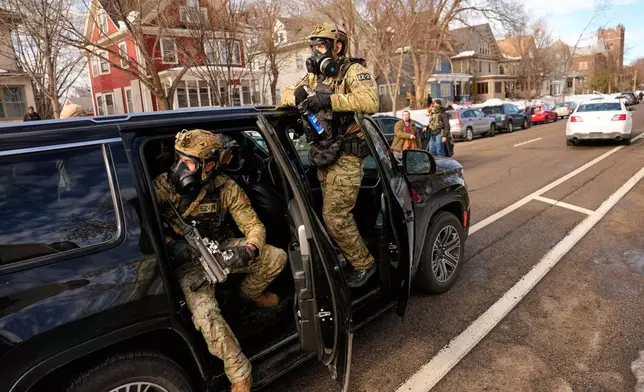 Federal immigration officers get in a car as they prepare to deploy tear gas at a protest, Monday, Jan. 12, 2026, in Minneapolis. (AP Photo/John Locher)