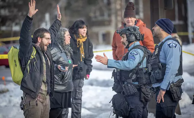 Protesters confront law enforcement officers at the scene of a shooting in Minneapolis, on Wednesday, Jan. 7, 2026. (Elizabeth Flores/Star Tribune via AP)