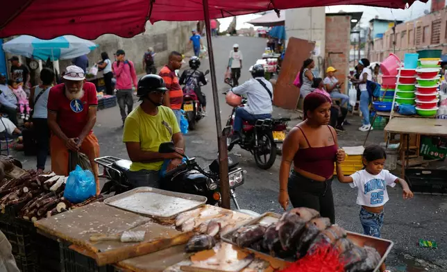 Vendors and shoppers fill a street market in the Petare neighborhood of Caracas, Venezuela, Wednesday, Jan. 7, 2026. (AP Photo/Matias Delacroix)