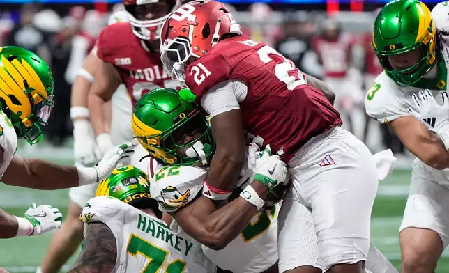 Oregon running back Jay Harris (22) carries for a touchdown against Indiana linebacker Rolijah Hardy (21) during the second half of the Peach Bowl NCAA college football playoff semifinal, Friday, Jan. 9, 2026, in Atlanta. (AP Photo/Brynn Anderson)