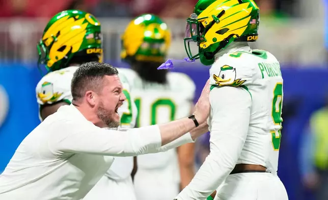 Oregon head coach Dan Lanning rallies linebacker Blake Purchase (9) before the Peach Bowl NCAA college football playoff semifinal against Indiana, Friday, Jan. 9, 2026, in Atlanta. (AP Photo/Brynn Anderson)