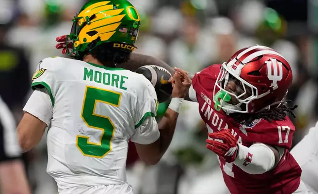 Indiana defensive lineman Daniel Ndukwe (17) pressures Oregon quarterback Dante Moore (5) during the first half of the Peach Bowl NCAA college football playoff semifinal, Friday, Jan. 9, 2026, in Atlanta. (AP Photo/Mike Stewart)