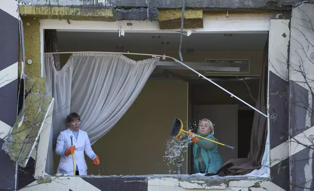 Medical workers remove the debris in a damaged private clinic after, according to Ukrainian officials, a Russian drone hit a hospital room killing a patient, in Kyiv, Ukraine, Monday, Jan 5, 2026. (AP Photo/Efrem Lukatsky)