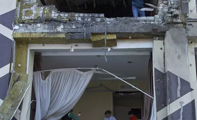 Medical workers remove the debris in a damaged private clinic after, according to Ukrainian officials, a Russian drone hit a hospital room killing a patient, in Kyiv, Ukraine, Monday, Jan 5, 2026. (AP Photo/Efrem Lukatsky)