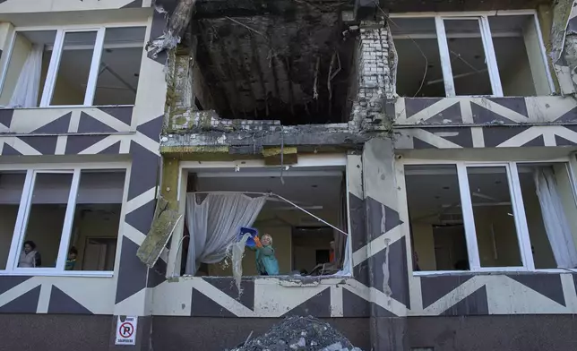 Medical workers remove the debris in a damaged private clinic after, according to Ukrainian officials, a Russian drone hit a hospital room killing a patient, in Kyiv, Ukraine, Monday, Jan 5, 2026. (AP Photo/Efrem Lukatsky)