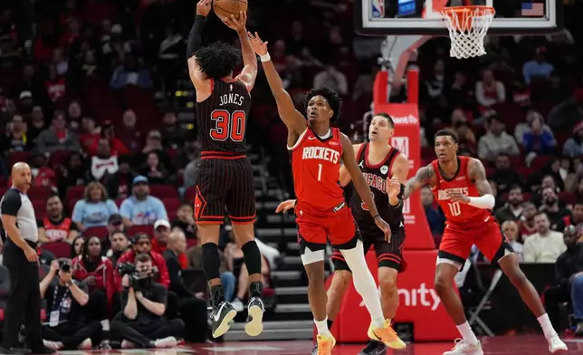 Chicago Bulls guard Tre Jones (30) shoots against Houston Rockets guard Amen Thompson (1) during the first half of an NBA basketball game in Houston, Tuesday, Jan. 13, 2026. (AP Photo/Ashley Landis)