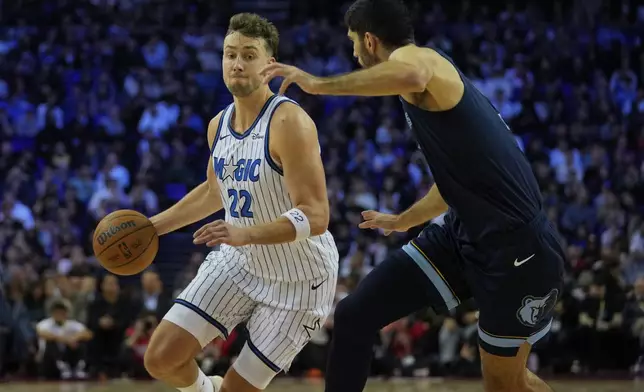 Orlando Magic forward Franz Wagner (22) drives around Memphis Grizzlies forward Santi Aldama (7) during the first half of NBA basketball game Sunday, Jan. 18, 2026, in London. (AP Photo/Kin Cheung)