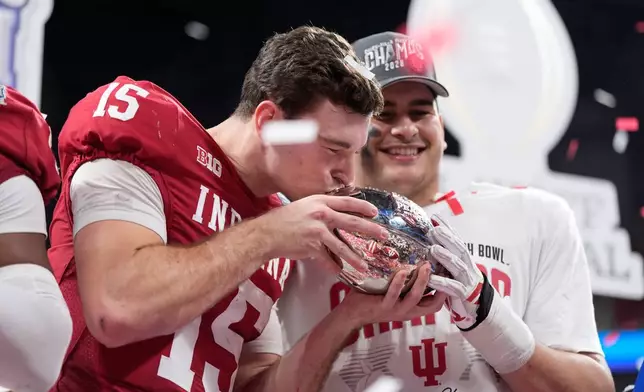 Indiana quarterback Fernando Mendoza (15) kisses the trophy after the Peach Bowl NCAA college football playoff semifinal against Oregon, Friday, Jan. 9, 2026, in Atlanta. (AP Photo/Brynn Anderson)