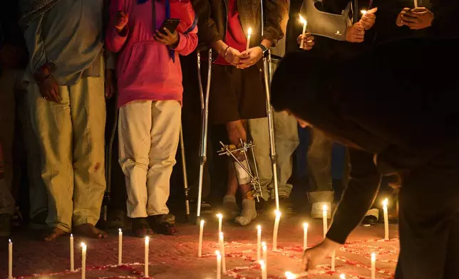 Members of Gen Z protest groups are joined by injured victims and family members of those who died during September protests at a candlelight vigil outside the Parliament building in Kathmandu, Nepal, on Dec. 9, 2025. (AP Photo/Niranjan Shrestha)