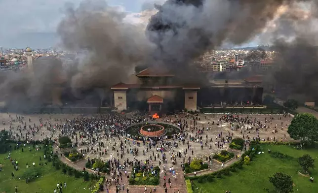 FILE - Protesters celebrate at the parliament building after it was set on fire during a protest against social media ban and corruption in Kathmandu, Nepal, on Sept. 9, 2025. (AP Photo/Prakash Timalsina, File)