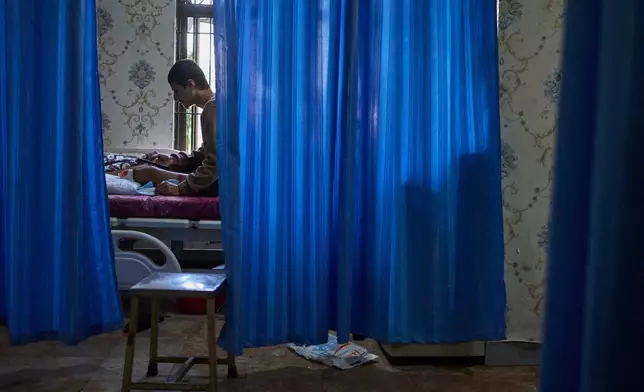 Mukesh Awasti, 22, who took part in September protests against corruption in Nepal and lost his leg after being shot by security forces, lies on a hospital bed during treatment in Kathmandu, Nepal, on Dec. 8, 2025. (AP Photo/Niranjan Shrestha)