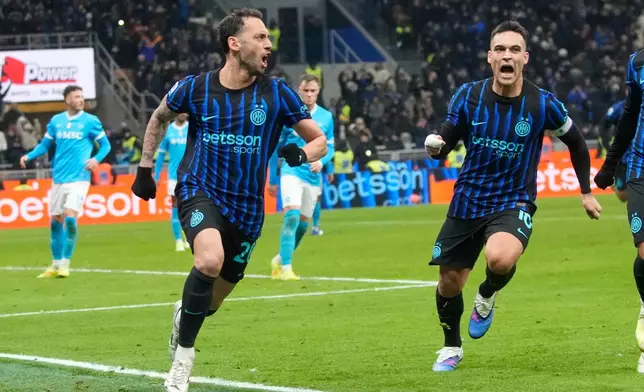 Inter Milan's Hakan Calhanoglu, centre left, celebrates with Lautaro Martinez after scoring his side's second goal during the Serie A soccer match between Inter Milan and Napoli in Milan, Italy, Sunday, Jan. 11, 2026. (AP Photo/Luca Bruno)