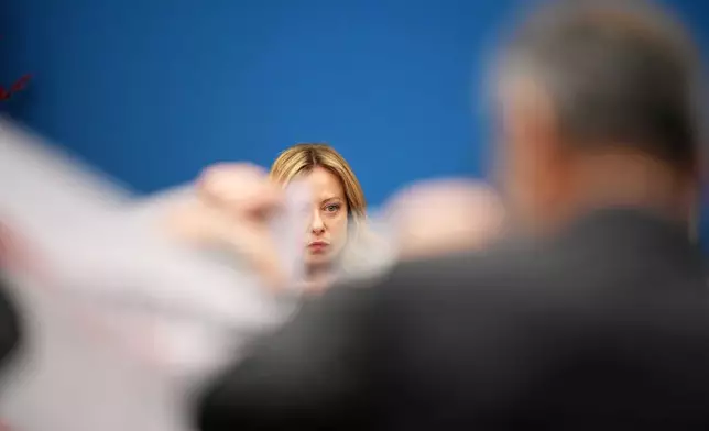 Italian journalists display banners demanding the renewal of their employment contracts in front of Italian Prime Minister Giorgia Meloni during her annual start-of-the-year press conference in the press room at the Lower Chamber, in Rome, Friday, Jan. 9, 2026. (AP Photo/Andrew Medichini)