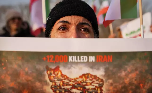 A woman cries as members of the Iranian community stage a rally in support of anti-government protests in Iran, outside the U.S. embassy in Bucharest, Romania, Wednesday, Jan. 14, 2026. (AP Photo/Andreea Alexandru)