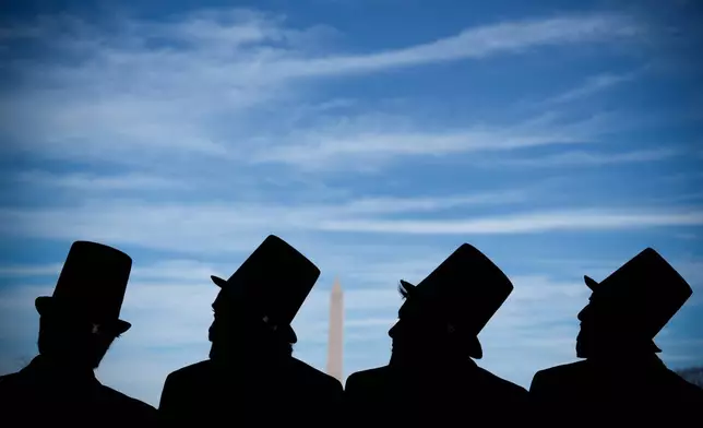FILE - Men dressed as former President Abraham Lincoln attend a mock funeral for the penny, which was discontinued earlier in the year, in front of the Lincoln Memorial in Washington, Dec. 20, 2025. (AP Photo/Julia Demaree Nikhinson, File)