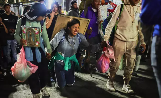 FILE - Pilgrims arrive at Our Lady of Guadalupe Basilica in Mexico City, Dec. 11, 2025, the night before her feast day. (AP Photo/Claudia Rosel, File)