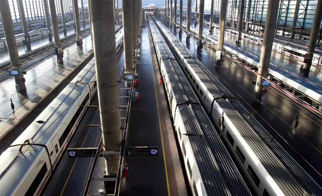 FILE - A worker cleans the windows of a high speed train at Atocha station in Madrid, March 29, 2012. (AP Photo/Paul White, File)
