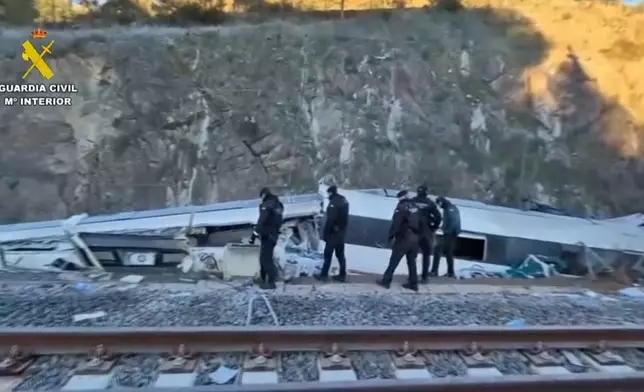 In this grab taken from video provided by Guardia Civil, rescue workers at the scene after a high speed train collision, near Adamuz, Spain, Monday, Jan. 19, 2026. (Guardia Civil via AP)