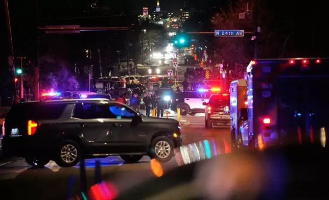 Law enforcement at the scene of a reported shooting Wednesday, Jan. 14, 2026, in Minneapolis. (AP Photo/John Locher)