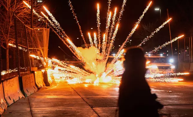 Fireworks are set off by protesters outside the Bishop Henry Whipple Federal Building, Monday, Jan. 12, 2026, in Minneapolis. (AP Photo/Jen Golbeck)
