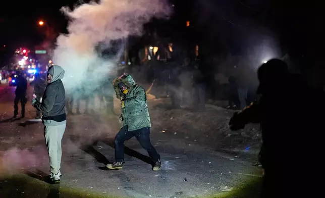 Protesters are hit with projectiles at the scene of a reported shooting Wednesday, Jan. 14, 2026, in Minneapolis. (AP Photo/John Locher)