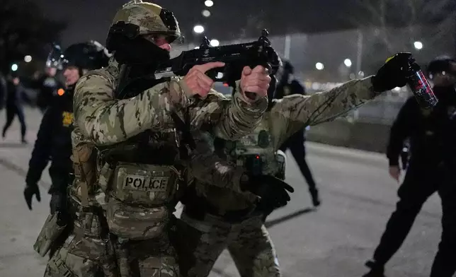 Federal immigration officers confront protesters outside Bishop Henry Whipple Federal Building, Thursday, Jan. 15, 2026, in Minneapolis. (AP Photo/Yuki Iwamura)