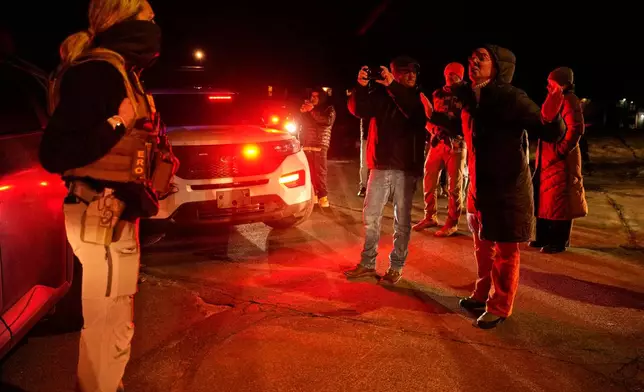 A woman confronts a federal immigration officer at the scene of a reported shooting Wednesday, Jan. 14, 2026, in Minneapolis. (AP Photo/John Locher)