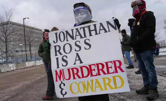 Protesters confront federal immigration officers outside the Bishop Henry Whipple Federal Building, Tuesday, Jan. 13, 2026, in Minneapolis. (AP Photo/Adam Gray)