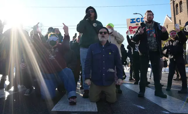 EDS NOTE: OBSCENITY - Protesters block the road as Federal agents try to leave Tuesday, Jan. 13, 2026, in Minneapolis.(AP Photo/Adam Gray)