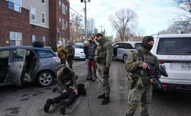 Protesters are detained by federal immigration officers Monday, Jan. 12, 2026, in Minneapolis. (AP Photo/Adam Gray)