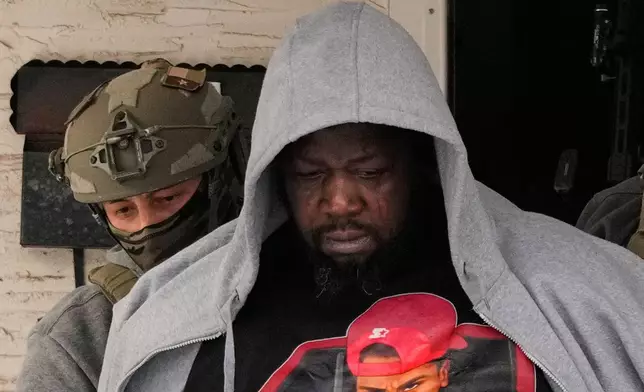 A man becomes emotional as he is arrested by federal immigration officers Sunday, Jan. 11, 2026, in Minneapolis. (AP Photo/John Locher)