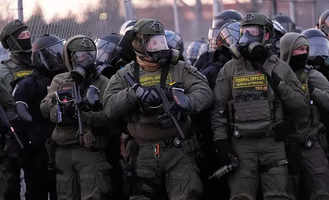 Federal officers stand outside the Bishop Henry Whipple Federal Building during a protest on Saturday, Jan. 17, 2026, in Minneapolis. (AP Photo/Yuki Iwamura)