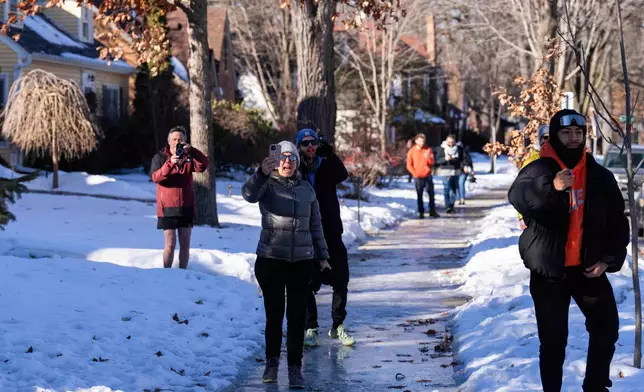 Residents and activists shout at U.S. Border Patrol officers for blocking a street in Minneapolis, Wednesday, Jan. 14, 2026. (AP Photo/Adam Gray)
