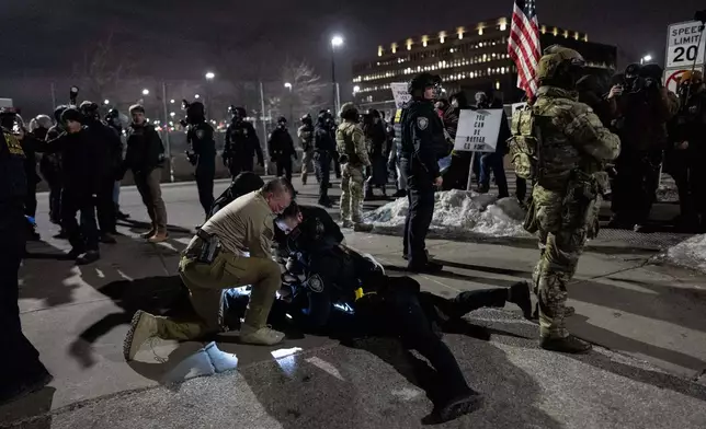 Federal immigration officers detain a protester outside Bishop Henry Whipple Federal Building, Thursday, Jan. 15, 2026, in Minneapolis. (AP Photo/Adam Gray)