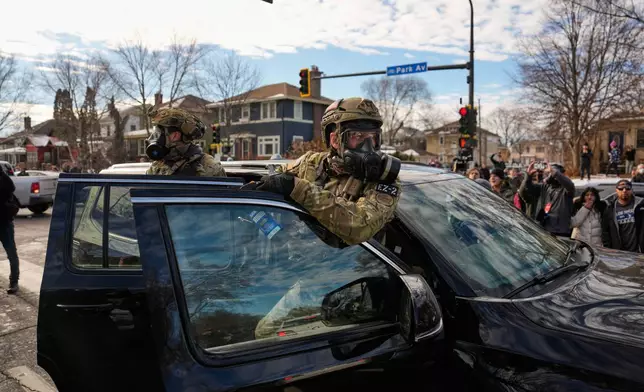 Federal immigration officers get in a car to leave a scene Monday, Jan. 12, 2026, in Minneapolis. (AP Photo/John Locher)
