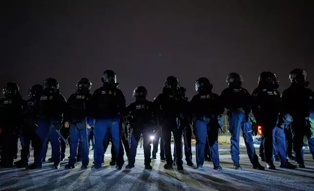 Federal immigration officers confront protesters outside Bishop Henry Whipple Federal Building, Thursday, Jan. 15, 2026, in Minneapolis. (AP Photo/Adam Gray)