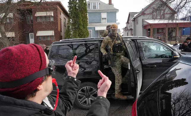 EDS NOTE: OBSCENITY - A person makes obscene gestures at Border Patrol agents after they've made arrests, Sunday, Jan. 11, 2026, in Minneapolis. (AP Photo/Adam Gray)