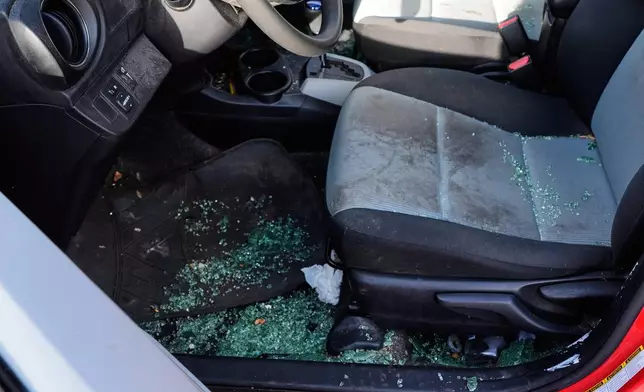 The car of Patty O'Keefe, a U.S. citizen who was arrested while following federal agents' vehicles and briefly held at a federal facility in Minneapolis, shows glass on the floor after her front driver's side window was smashed in, Tuesday, Jan. 13, 2026. (AP Photo/Jen Golbeck)