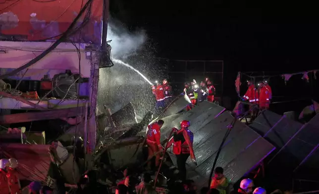 Lebanese fire fighter extinguish a building destroyed by an Israeli airstrike in the southern port city of Sidon, Lebanon, early Tuesday, Jan. 6, 2026. (AP Photo/Mohammed Zaatari)