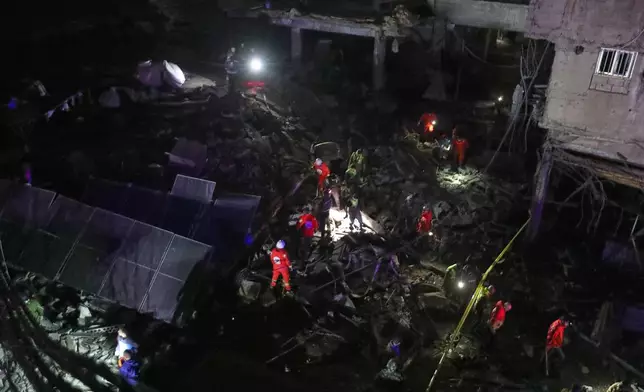 Lebanese Red Cross volunteers search for possible victims in a building destroyed by an Israeli airstrike in the southern port city of Sidon, Lebanon, early Tuesday, Jan. 6, 2026. (AP Photo/Mohammed Zaatari)