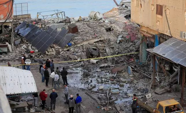 People check a destroyed building that was hit by an Israeli airstrike at a commercial district in the southern port city of Sidon, Lebanon, Tuesday, Jan. 6, 2026. (AP Photo/Mohammed Zaatari)