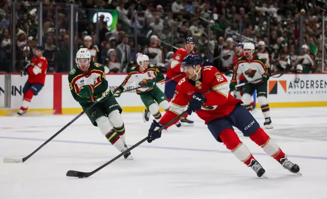 Florida Panthers' Sam Reinhart (13) controls the puck against the Minnesota Wild during the second period of an NHL hockey game, Saturday, Jan. 24, 2026, in St. Paul, Minn. (AP Photo/Lily Dozier)