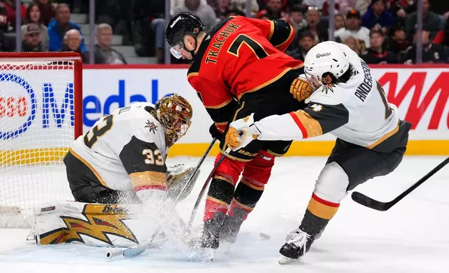 Ottawa Senators' Brady Tkachuk (7) looks for the rebound in front of Vegas Golden Knights goaltender Adin Hill (33) as Rasmus Andersson (4) defends, during the second period of an NHL hockey game in Ottawa, Sunday, Jan. 25, 2026. (Justin Tang/The Canadian Press via AP)