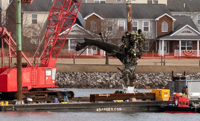 FILE - Rescue and salvage crews pull up a part of a Army Black Hawk helicopter that collided midair with an American Airlines jet, at a wreckage site in the Potomac River from Ronald Reagan Washington National Airport, Feb. 6, 2025, in Arlington, Va. (AP Photo/Jose Luis Magana, File)