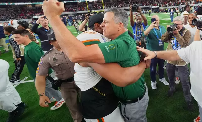 Miami head coach Mario Cristobal, right, hugs defensive lineman Ahmad Moten Sr. following the Cotton Bowl College Football Playoff quarterfinal game against Ohio State Wednesday, Dec. 31, 2025, in Arlington, Texas. (AP Photo/Julio Cortez)
