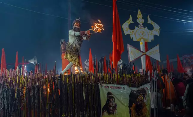 A Hindu holy man prays on the eve of Mauni Amavasya, a divine occasion in Hindu religious practice followed for honoring ancestors or forefathers, at the Sangam, the confluence of the Ganges, the Yamuna and the mythical Saraswati rivers, during the annual month long Hindu religious fair "Magh Mela" in Prayagraj, India, Saturday, Jan.17, 2026. (AP Photo/Rajesh Kumar Singh)