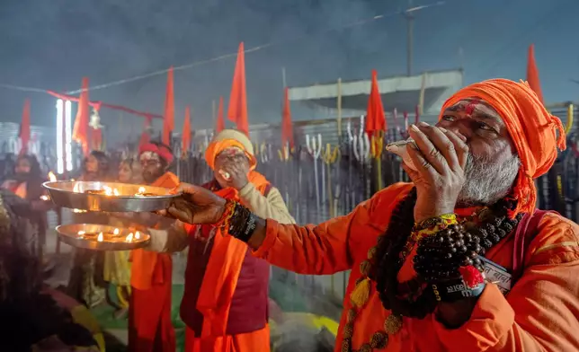 Hindu holy men pray on the eve of Mauni Amavasya, a divine occasion in Hindu religious practice followed for honoring ancestors or forefathers, at the Sangam, the confluence of the Ganges, the Yamuna and the mythical Saraswati rivers, during the annual month long Hindu religious fair "Magh Mela" in Prayagraj, India, Saturday, Jan.17, 2026. (AP Photo/Rajesh Kumar Singh)