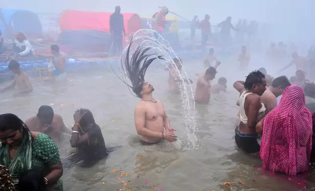 Devotees take a holy dip on Mauni Amavasya, a divine occasion in Hindu religious practice followed for honoring ancestors or forefathers, at the Sangam, the confluence of the Ganges, the Yamuna and the mythical Saraswati rivers, during the annual month long Hindu religious fair "Magh Mela" in Prayagraj, India, Sunday, Jan.18, 2026. (AP Photo/Rajesh Kumar Singh)