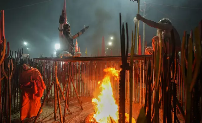 Hindu holy men pray on the eve of Mauni Amavasya, a divine occasion in Hindu religious practice followed for honoring ancestors or forefathers, at the Sangam, the confluence of the Ganges, the Yamuna and the mythical Saraswati rivers, during the annual month long Hindu religious fair "Magh Mela" in Prayagraj, India, Saturday, Jan.17, 2026. (AP Photo/Rajesh Kumar Singh)