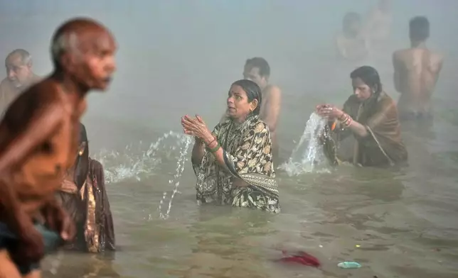 Devotees take a holy dip on Mauni Amavasya, a divine occasion in Hindu religious practice followed for honoring ancestors or forefathers, at the Sangam, the confluence of the Ganges, the Yamuna and the mythical Saraswati rivers, during the annual month long Hindu religious fair "Magh Mela" in Prayagraj, India, Sunday, Jan. 18, 2026. (AP Photo/Rajesh Kumar Singh)